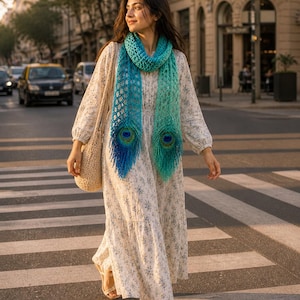 May include: A woman wearing a long, floral print dress and a blue and green peacock feather scarf. She is carrying a beige bag and wearing sandals while crossing a crosswalk in a city.