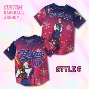 Puede incluir: Camiseta de b&eacute;isbol personalizada con tem&aacute;tica invernal. La camiseta es principalmente roja y azul, con un personaje de dibujos animados, copos de nieve y el nombre "Hans" con el n&uacute;mero "00". Tambi&eacute;n es visible el texto "YOUR NAME".
