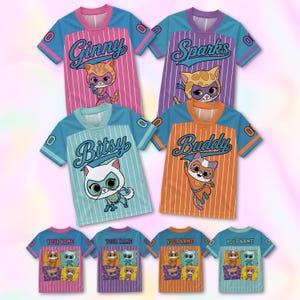 May include: Four short-sleeved jerseys featuring cartoon cats in superhero masks. The shirts are pink, purple, light blue, and orange with white pinstripes, blue sleeves, and names Ginny, Sparks, Bitsy, and Buddy. The backs display the text YOUR NAME.