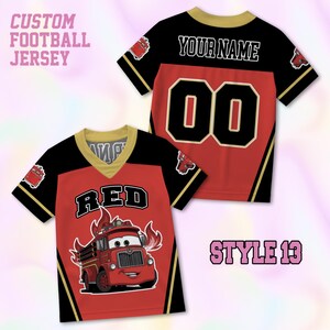 May include: A custom football jersey featuring a red, black, and gold color scheme. The front displays a cartoon fire truck graphic with the text RED. The back shows the text YOUR NAME and the number 00. The jersey has a V-neck collar.