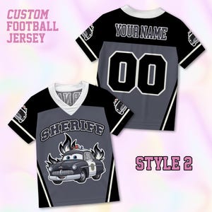 May include: A custom football jersey in black, gray, and white. The front features a cartoon police car graphic with the text SHERIFF. The back displays the text YOUR NAME and the number 00. The text CUSTOM FOOTBALL JERSEY and STYLE 2 are visible.