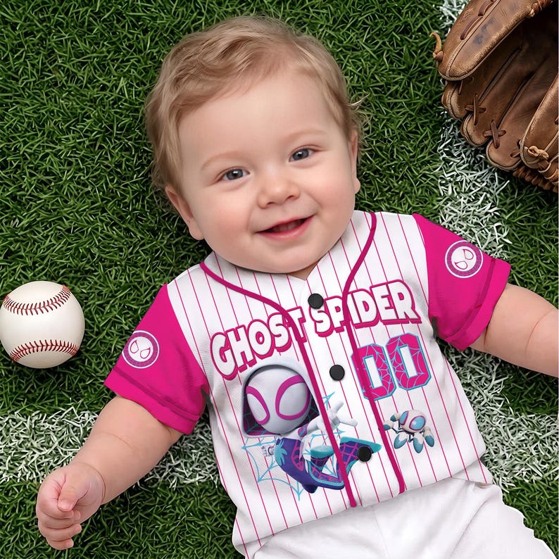 May include: A white and pink pinstriped baseball jersey featuring the text GHOST SPIDER, the number 00, and a graphic of the Ghost Spider character. The shirt has short pink sleeves with circular spider icons and a button-down front design.