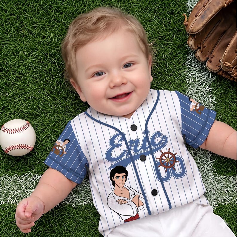 May include: A baby in a white and blue pinstripe baseball jersey with the name "Eric" in blue script. The jersey has black buttons and a cartoon illustration. A baseball and a baseball glove are also in the image.
