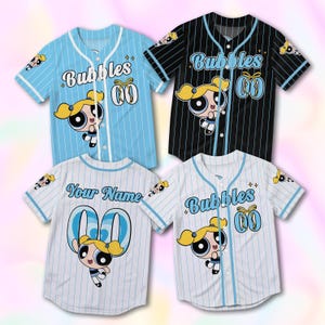 May include: Four baseball jerseys with cartoon character Bubbles. The jerseys are light blue, black, and white with pinstripes. Each jersey has the word "Bubbles" or "Your Name" on the front, along with a cartoon image of Bubbles.