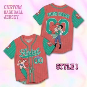 May include: Custom baseball jersey in red with green sleeves and accents. Features the name "Ariel" and the number "00" on the front, and "YOUR NAME" and "00" on the back. Includes a cartoon illustration of Ariel and Prince Eric.