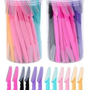 May include: Two clear plastic containers filled with colorful eyebrow razors. The razors are in shades of pink, black, purple, teal, and yellow. A row of razors in various colors is displayed below the containers.