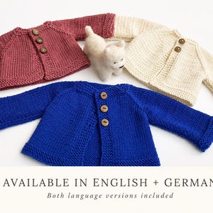 Pode incluir: Três cardigãs tricotados à mão em rosa antigo, creme e azul royal, cada um com três botões de madeira e mangas compridas. Uma pequena figura de cão em lã feltrada branca está posicionada entre eles. Texto: AVAILABLE IN ENGLISH + GERMAN.
