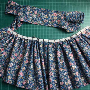 Summer doll clothes sewing pattern set for Waldorf dolls, includes linen romper, white ruffle blouse, denim pants, floral dress, and lace-trimmed playsuit. Handmade doll outfit tutorial, PDF download, perfect for 15-18 inch dolls and DIY doll wardrobes