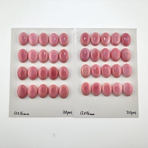 Può includere: Due cartoncini bianchi contenenti ciascuno 20 cabochon ovali rosa disposti in quattro file da cinque. Ogni cabochon ha una superficie liscia e lucida. Il testo 12x16mm e 20pcs è stampato in inchiostro nero nella parte inferiore di ogni carta.