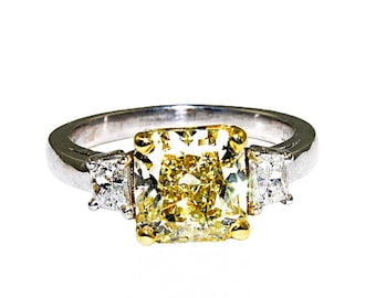 Anillo de platino con diamantes talla cojín y trapecio de 3,00 ct amarillo fantasía, certificado por GIA.