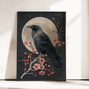 Könnte beinhalten: Ein rechteckiger Wandkunstdruck mit dunkelgrauem Hintergrund und einem großen, blassen, kreisförmigen Mond. Ein schwarzer Rabe sitzt auf einem hellen Ast, der mit zahlreichen kleinen, zarten rosa Kirschblüten und Knospen geschmückt ist.