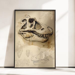 May include: A framed art print featuring a detailed, sepia-toned illustration of a dinosaur skull. The artwork includes a large, shaded central skull drawing, smaller anatomical sketches, and handwritten cursive notes on a parchment-like background.