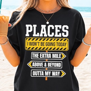 May include: A black t-shirt featuring white text that reads PLACES I WON'T BE GOING TODAY inside a yellow caution sign graphic. Below are three white directional signs with black text: THE EXTRA MILE, ABOVE & BEYOND, and OUTTA MY WAY.