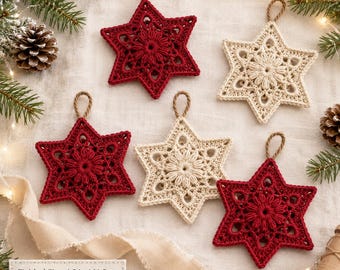 May include: Five star-shaped crochet ornaments in deep red and cream colors, each featuring a central floral pattern and a small hanging loop. A label indicates a finished size of 4.5 inches or 11.5 cm for these decorative items.