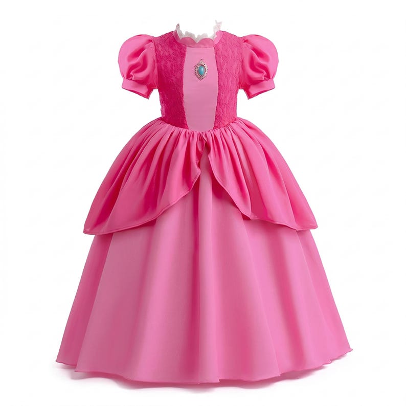 May include: A pink princess dress with short, puffy sleeves and a full skirt. The bodice features a textured pink fabric with a central panel and a small, round, turquoise-colored jewel. The dress has a high, ruffled neckline.