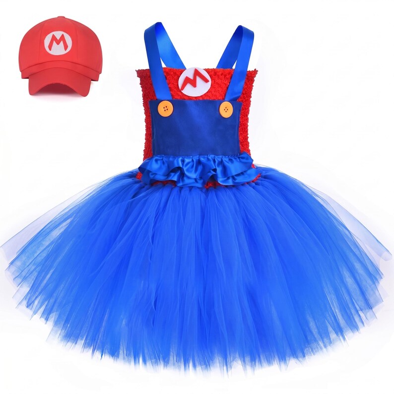 Op de afbeelding: Een rood en blauw tutu-jurkje met een textuurrijk rood lijfje, een blauw satijnachtig paneel met twee gele knopen, blauwe schouderbandjes en een volle blauwe tule rok. Een rode baseballpet met een witte cirkel en rode letter M is inbegrepen.