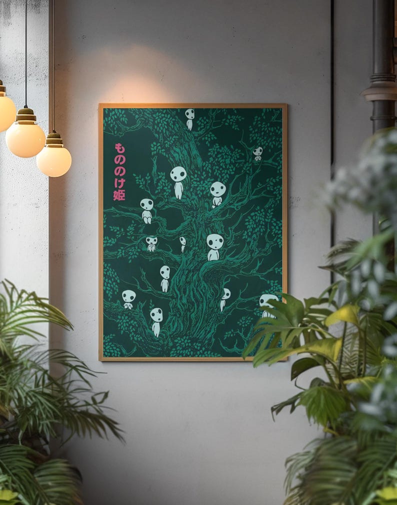 May include: A framed art print featuring a dark green illustration of a tree filled with white, spirit-like figures. The Japanese text "もののけ姫" is printed in pink on the left side. The artwork is displayed in a room with hanging lights and plants.