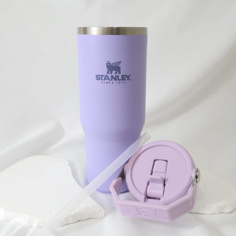 Pu&ograve; includere: Un bicchiere Stanley color lavanda con bordo argentato, coperchio e cannuccia. Il bicchiere presenta il logo Stanley e la scritta "SINCE 1913". Il coperchio &egrave; lilla chiaro e ha una chiusura a ribalta. La cannuccia &egrave; trasparente.