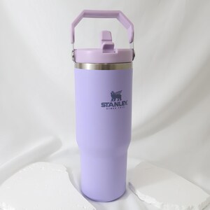 Pu&ograve; includere: Un bicchiere Stanley lavanda con manico e coperchio abbinati. Il bicchiere in acciaio inossidabile ha il logo Stanley stampato sul davanti. Il bicchiere &egrave; progettato per mantenere le bevande fredde o calde. Il bicchiere &egrave; alto circa 24 cm.