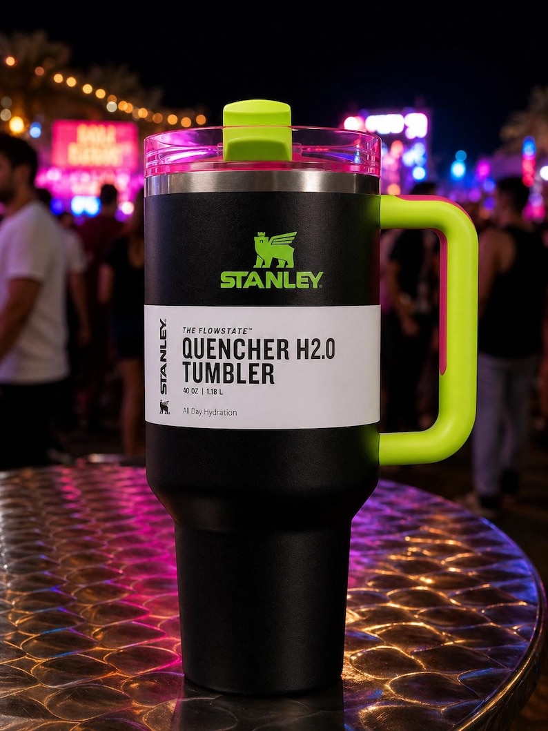 Pu&ograve; includere: Bicchiere Stanley Quencher H2.0 nero e verde neon. Il bicchiere ha un corpo nero con manico, coperchio e cannuccia verde neon. Il testo "STANLEY" e "QUENCHER H2.0 TUMBLER" sono stampati. Capacit&agrave;: 1,18 L.