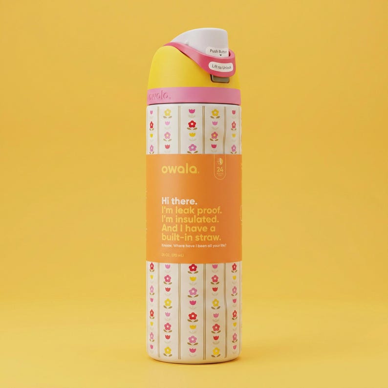 Peut inclure: Une gourde Owala jaune, rose et blanche avec un motif floral et une paille int&eacute;gr&eacute;e. La gourde a une poign&eacute;e rose et un bouton-poussoir blanc. Le texte sur la gourde dit : "Hi there. I'm leak proof. I'm insulated. And I have a built-in straw."