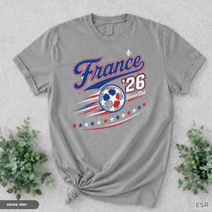 A gray t-shirt with a graphic design featuring a soccer ball and the text "France '26 Soccer Club" printed on it.