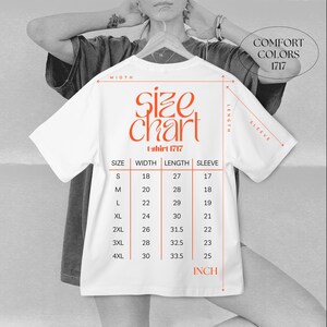 The image is a black and white photo of a person wearing a white t-shirt with a size chart printed on it.