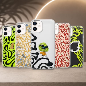 Puede incluir: Cinco fundas transparentes para smartphone con varios diseños: una funda verde neón con un número 1 negro, un patrón de mariposas amarillas, una funda central con un personaje de piloto de carreras, un patrón abstracto rojo y una funda negra con un 4 verde neón.