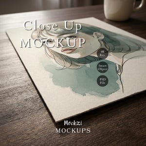 Może przedstawiać: Zbliżenie akwarelowego portretu kobiety w odcieniach niebieskiego i szarego. Obraz znajduje się na papierze o fakturze, z białym napisem "Close Up MOCKUP". Dodatkowy tekst zawiera "4K Res., Smart Object, PSD File" i "Mockzi MOCKUPS."