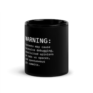 Puede incluir: Taza de café negra con texto blanco. El texto dice: "ADVERTENCIA: El contenido puede causar depuración excesiva, opiniones no solicitadas sobre pestañas vs espacios y commits git espontáneos."