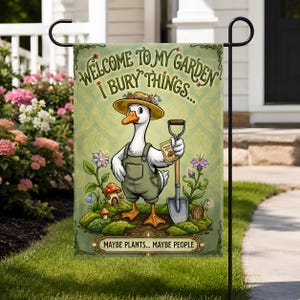 May include: A rectangular garden flag featuring a white goose wearing a straw hat and green overalls, holding a shovel and a seed packet. The text reads: WELCOME TO MY GARDEN I BURY THINGS... MAYBE PLANTS... MAYBE PEOPLE. The background is light green.