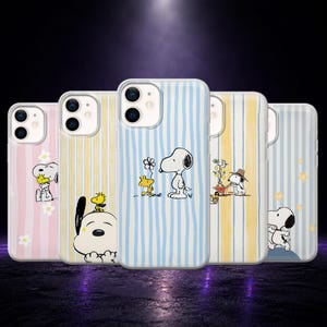 May include: Five clear smartphone cases featuring Peanuts characters. The designs include Snoopy and Woodstock with vertical stripes in pastel pink, yellow, and blue, accented by white daisies, a small wheelbarrow, and yellow stars.