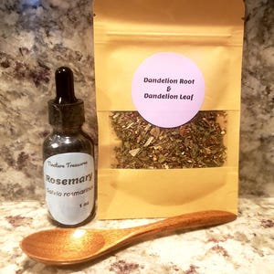 May include: A 1 oz glass dropper bottle labeled Tincture Treasures Rosemary Salvia rosmarinus, a tan pouch labeled Dandelion Root & Dandelion Leaf containing dried herbs, and a smooth wooden spoon placed in front of the items.