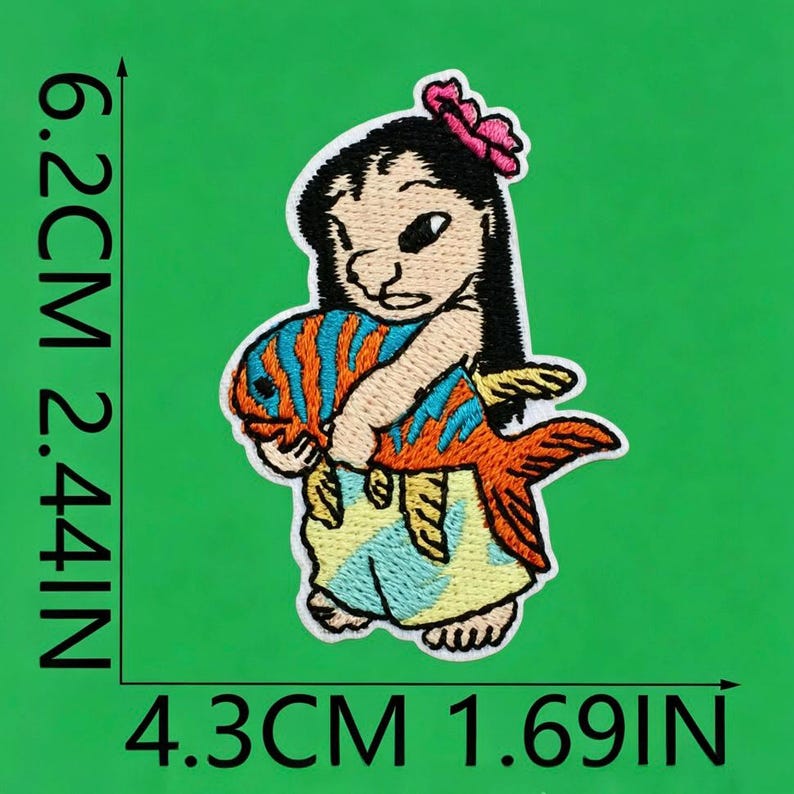 May include: An embroidered patch featuring a character with black hair and a pink flower, holding an orange fish with blue stripes. The character wears a light blue skirt. The patch measures 6.2 cm by 4.3 cm, or 2.44 inches by 1.69 inches.