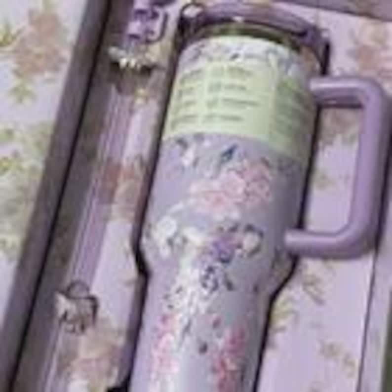 Pu&ograve; includere: Un bicchiere in acciaio inossidabile color lavanda con un motivo floreale di fiori rosa e bianchi, un manico viola abbinato e un coperchio trasparente. Il bicchiere include una cannuccia ed &egrave; presentato in una scatola con stampa floreale coordinata.