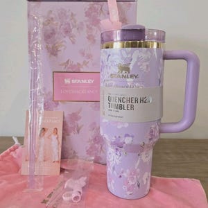 Pu&ograve; includere: Un bicchiere Stanley Quencher H2.0 color lavanda con motivo floreale, manico e coperchio. Il bicchiere &egrave; accompagnato da una scatola abbinata, una sacca rosa con coulisse, una cannuccia trasparente e un accessorio. L'etichetta riporta Stanley LoveShackFancy.