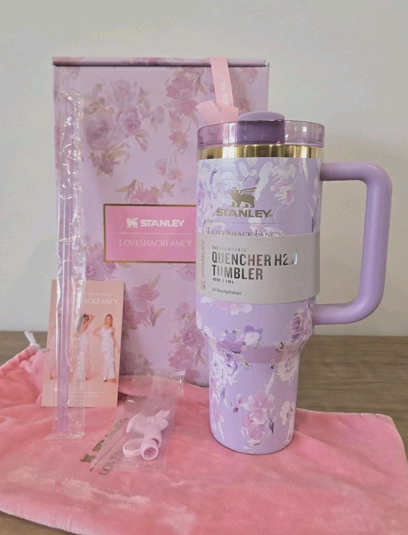 Pu&ograve; includere: Un bicchiere Stanley Quencher H2.0 color lavanda con motivo floreale, manico e coperchio. Il bicchiere &egrave; accompagnato da una scatola abbinata, una sacca rosa con coulisse, una cannuccia trasparente e un accessorio. L'etichetta riporta Stanley LoveShackFancy.