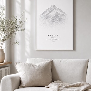 Könnte beinhalten: Ein gerahmter vertikaler Wandkunstdruck mit einer detaillierten schwarz-weißen Strichzeichnung des Ortler-Gipfels. Der Text unter der Bergillustration lautet ORTLER, 3905 m, 46.5167 N, 10.5344 E und ITALY in einer klaren Schriftart.