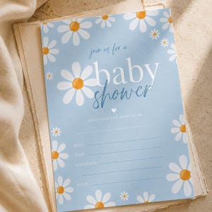 Könnte beinhalten: Babyparty-Einladung mit hellblauem Hintergrund und weißen Gänseblümchen mit gelben Zentren. Die Einladung lautet "join us for a baby shower" und enthält Platz für Datum, Uhrzeit, Ort und RSVP-Informationen.