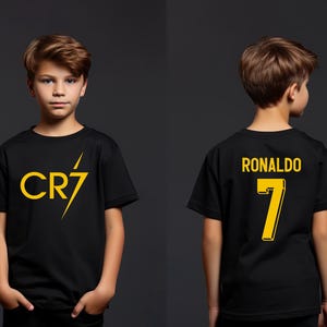a young boy wearing a black shirt with the number seven on it