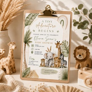Puede incluir: Una invitaci&oacute;n de baby shower en un portapapeles con el texto A TINY ADVENTURE BEGINS, Olivia Snow's BABY SHOWER y detalles del evento. El dise&ntilde;o incluye ilustraciones en acuarela de una jirafa, un elefante, un cachorro de le&oacute;n y una cebra.