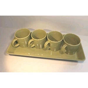 May include: A set of four olive green ceramic mugs with handles, arranged on a matching rectangular tray. The mugs and tray have a smooth, matte finish. This set is ideal for serving coffee or tea.