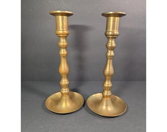 Candelabros antiguos de latón, par de portavelas altos y cónicos con tallo torneado clásico.