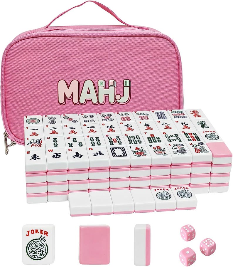 May include: A pink Mahjong set with white and pink tiles, dice, and accessories. The set includes a pink carrying case with the word "MAHJ" printed on it. The tiles are arranged in a stack, with some tiles and accessories placed in front.