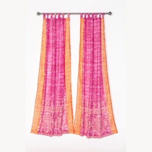 May include: A pair of pink and orange patterned curtains with a paisley design. The curtains are hung on a silver rod.