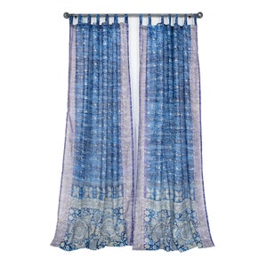 Peut inclure: Une paire de rideaux transparents à motifs bleus et blancs avec un design à nouer en haut. Les rideaux sont suspendus à une tringle argentée.