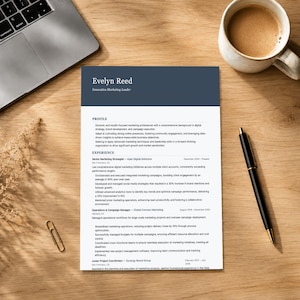 Può includere: Un curriculum vitae su una scrivania di legno con un laptop e una tazza di caffè. Il curriculum vitae è intitolato "Evelyn Reed, Innovative Marketing Leader". Una penna nera e una graffetta sono anche sulla scrivania.