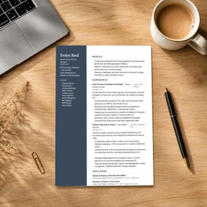 Può includere: Un curriculum vitae intitolato "Evelyn Reed" con una barra laterale blu scuro, un laptop, una tazza di caffè, una penna e una graffetta su una scrivania di legno. Il curriculum vitae descrive competenze, esperienza e istruzione. La tazza di caffè è bianca con un liquido marrone.