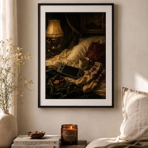May include: A framed wall art print depicting a cozy bedroom scene with a glowing lamp, a handheld gaming console, a ceramic mug, a pair of knit socks, and a small bowl of fruit resting on a rumpled bed with dark green and white bedding.