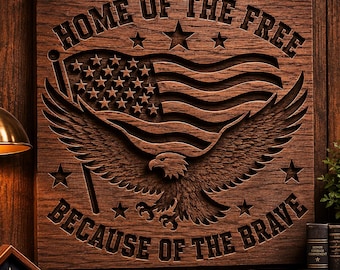 May include: A square wooden wall plaque featuring a deep-relief carving of an American flag and a bald eagle with wings spread. The text "HOME OF THE FREE" is carved at the top and "BECAUSE OF THE BRAVE" is carved at the bottom in block letters.